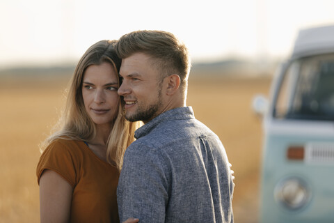 Zärtliches junges Paar am Wohnmobil in ländlicher Landschaft, lizenzfreies Stockfoto