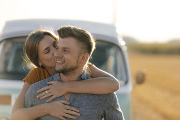 Happy affectionate young couple at camper van in rural landscape - GUSF01561