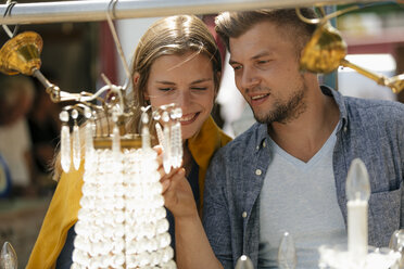 Belgien, Tongeren, glückliches junges Paar auf einem Antiquitätenflohmarkt - GUSF01587
