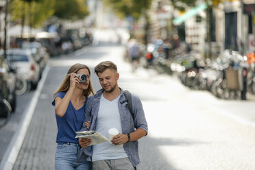 Netherlands, Maastricht, young couple exploring the city taking pictures - GUSF01594