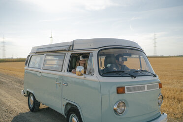 Young couple wearing VR glasses driving camper van in rural landscape - GUSF01651