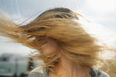 Blonde junge Frau im Wohnmobil schüttelt ihr Haar, lizenzfreies Stockfoto