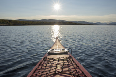 Finland, Lappland, Kilpisjaervi, canoe on lake against the sun - PSIF00160