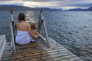 Finnland, Lappland, Kilpisjaervi, Mutter und Tochter sitzen draußen auf der Promenade, Rückansicht - PSIF00163