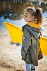 Mädchen mit gelber Luftmatratze am Strand im Herbst - HMEF00079