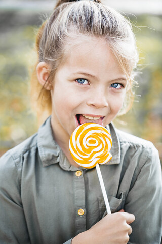 Porträt eines Mädchens, das einen Lolli leckt, lizenzfreies Stockfoto