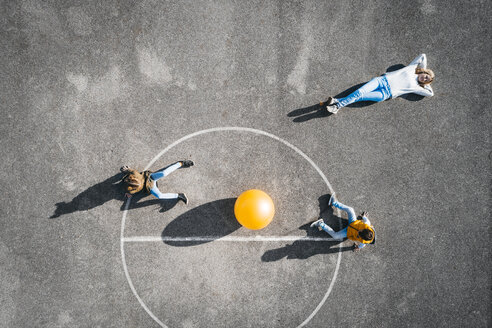 Österreich, Luftaufnahme, Blick auf Basketballfeld mit großem Ball, Mutter liegt am Boden, Kinder sitzen - HMEF00099