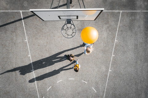 Österreich, Luftaufnahme eines Basketballplatzes, Mutter und Kinder spielen Basketball mit großem Ball, lizenzfreies Stockfoto