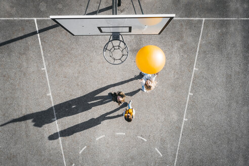 Austria, Aerial view of basketball field, mother and children playing basketball with big ball - HMEF00100