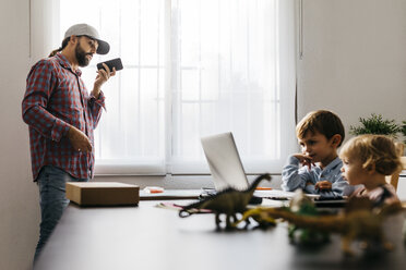 Father recording audio file, while children are using his laptop - JRFF01987