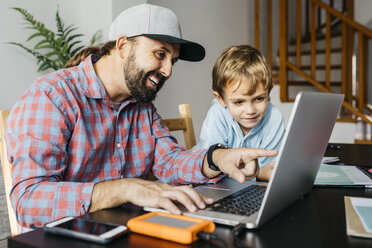 Vater und Sohn benutzen gemeinsam einen Laptop - JRFF01999