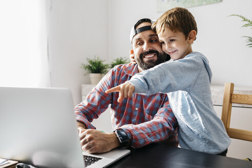 Vater und Sohn benutzen gemeinsam einen Laptop - JRFF02010