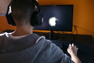 Junger Mann sitzt an seinem PC und spielt Computerspiele - JRFF02014