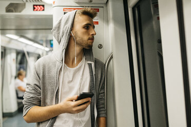 Junger Mann benutzt Smartphone in der U-Bahn - JRFF02028