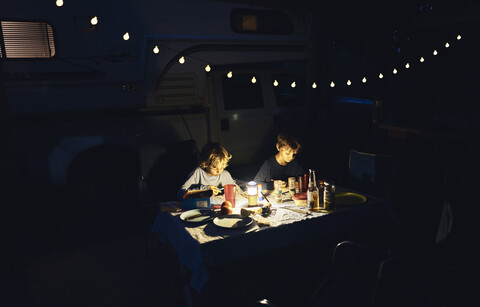 Brasilien, Bonito, zwei Jungen zeichnen im Dunkeln am Wohnmobil, lizenzfreies Stockfoto