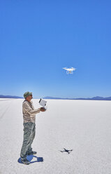 Bolivien, Salar de Uyuni, Mann fliegt Drohne auf Salzsee - SSCF00017