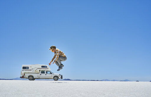 Bolivien, Salar de Uyuni, Junge springt auf Wohnmobil am Salzsee - SSCF00019