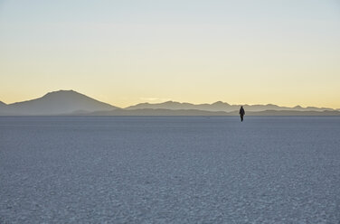 Bolivien, Salar de Uyuni, Frau geht bei Sonnenuntergang am Salzsee spazieren - SSCF00023
