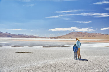 Bolivia, Laguna Colorada, mother and son at lakeshore with view to the Andes - SSCF00034