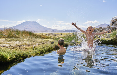 Chile, Salar del Carmen, zwei Jungen beim Baden in einer heißen Quelle, lizenzfreies Stockfoto