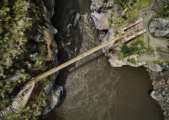 Peru, Quehue, Luftaufnahme einer Frau beim Überqueren einer Seilbrücke - SSCF00053