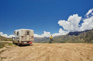 Peru, Chivay, Colca Canyon, woman with sons next to camper looking at canyon - SSCF00069