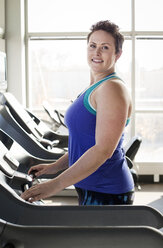 Portrait of woman exercising on treadmill in gym - CAVF56004