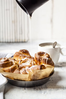 Selbstgebackene Zimtschnecken mit Puderzucker bestreuen - SBDF03847