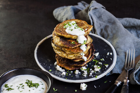 Stack of zucchini fritters with garlic yogurt sauce and feta stock photo