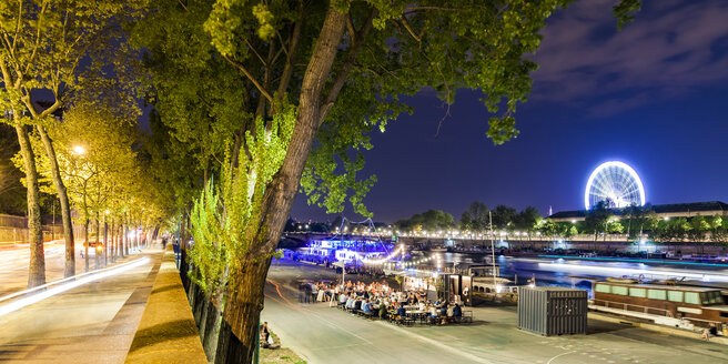 France, Paris, Champs-Elysees, Quai Anatole, people at River Seine bank at night - WDF04889