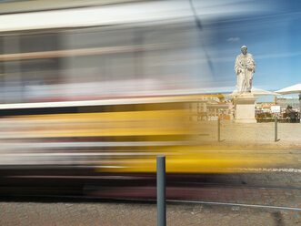 Portugal, Grande Lisboa, Lissabon, fahrende Straßenbahn und Statue des Vinzenz von Saragossa - LAF02179