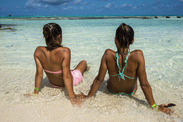 Carribean, Colombia, San Andres, El Acuario, rear view of two women sitting in shallow water - RUNF00246