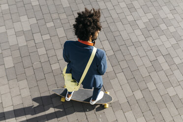 Junger Geschäftsmann fährt Skateboard auf einem Platz - JRFF02051