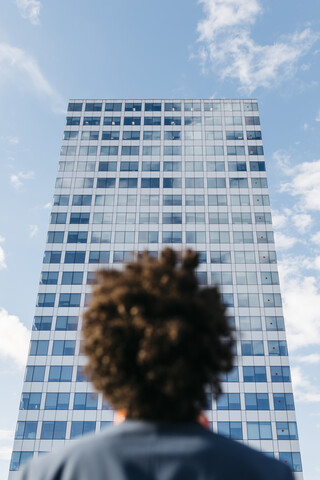 Spain, Barcelona, rear view of a young businessman looking at office block in the city stock photo