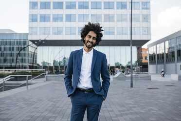 Spain, Barcelona, portrait of stylish young businessman standing in the city - JRFF02075