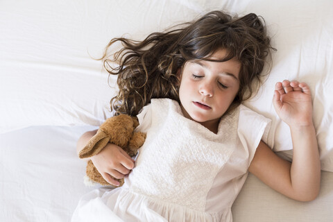 Little girl sleeping in bed stock photo