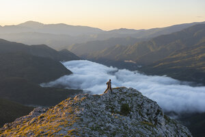 Italien, Umbrien, Nationalpark Sibillini, Wanderer auf Aussichtspunkt bei Sonnenaufgang - LOMF00749