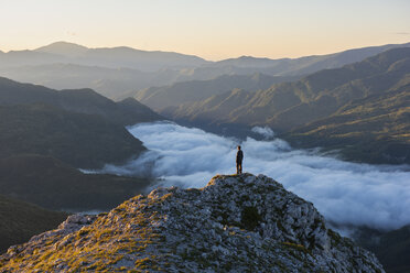 Italy, Umbria, Sibillini National Park, hiker standing on viewpoint at sunrise - LOMF00750