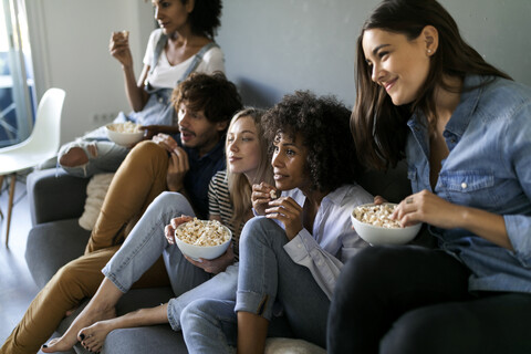 Freunde sitzen auf der Couch und sehen fern, lizenzfreies Stockfoto