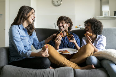 Cheerful friends sitting on couch drinking beer and eating pizza - VABF01816