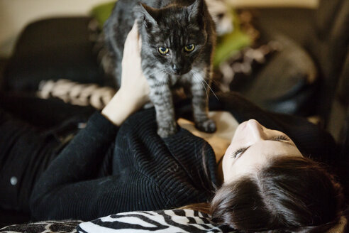 Portrait of grey tabby cat and owner on the couch at home - JATF01066