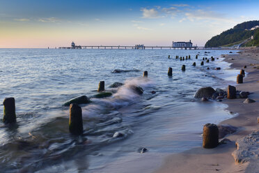 Deutschland, Mecklenburg-Vorpommern, Rügen, Sellin, alter Wellenbrecher am Strand, im Hintergrund die Selliner Seebrücke - FDF00277