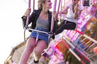 Mother and daughter having fun on chairoplane - FBAF00167