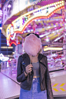 Teenagerin versteckt ihr Gesicht hinter rosa Zuckerwatte auf dem Jahrmarkt - FBAF00168