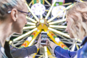 Mutter und Tochter fotografieren das Riesenrad auf dem Jahrmarkt - FBAF00175