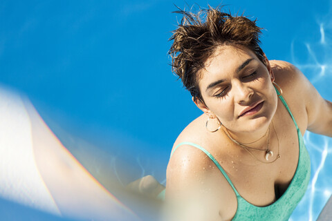 Porträt einer jungen Frau, die sich im Schwimmbad entspannt, lizenzfreies Stockfoto
