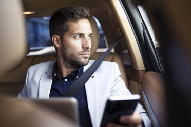 Junger Geschäftsmann sitzt im Auto und benutzt sein Smartphone - JSRF00084