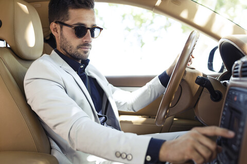 Erfolgreicher junger Geschäftsmann fährt in seinem Auto, lizenzfreies Stockfoto