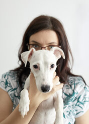 Porträt eines weißen Hundes mit Besitzer im Hintergrund - ZEDF01784