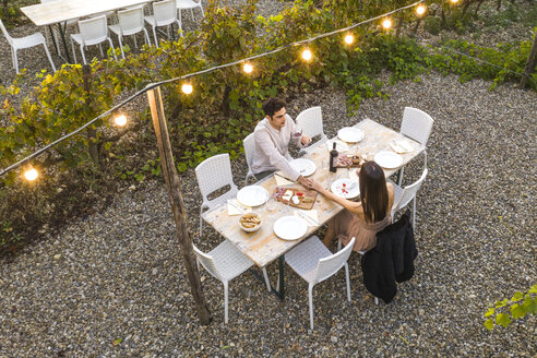 Italien, Toskana, Siena, junges Paar bei einem romantischen Abendessen in einem Weinberg - FBAF00187